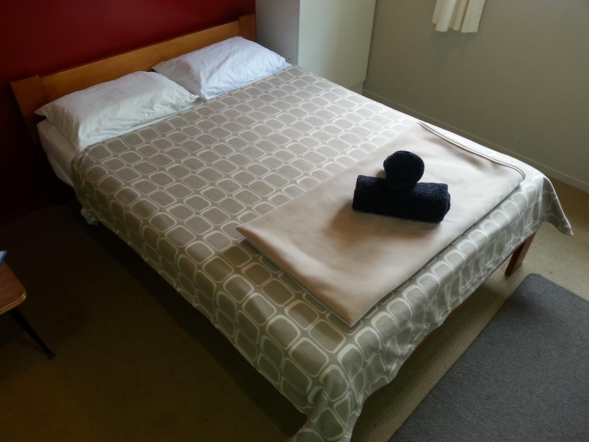 Riverstone Lodge Turangi Extérieur photo A bed with a duvet